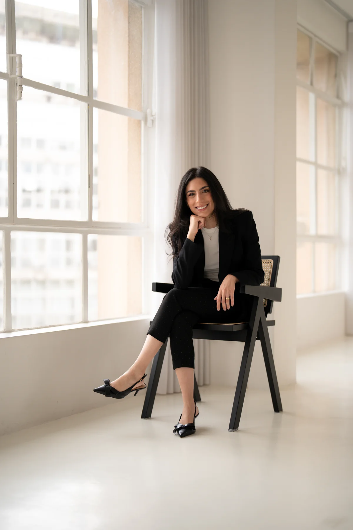 Dra. Rafaella Tacla sentada junto à janela
